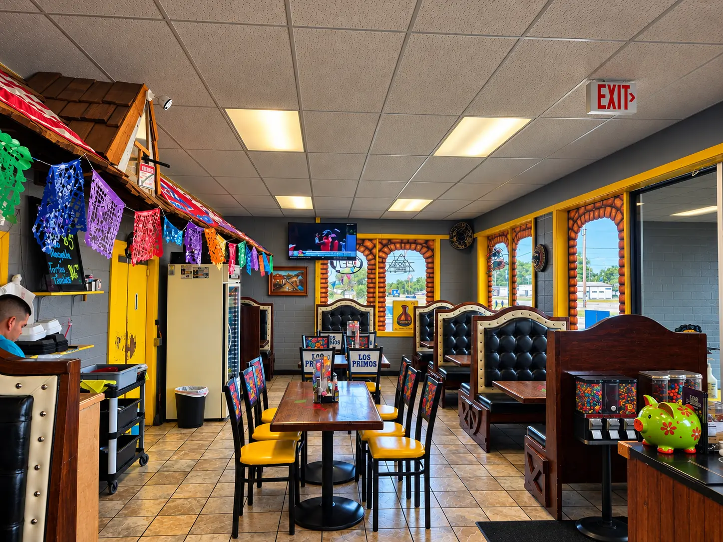 Colorful Los Primos dining room with papel picado banners and booths