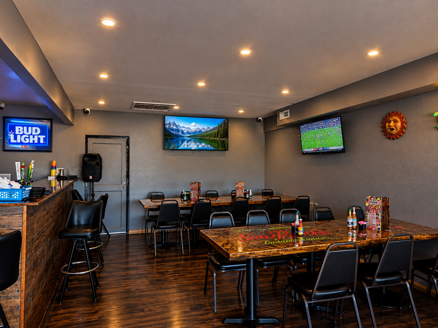 Los Primos dining room with painted table tops and TVs